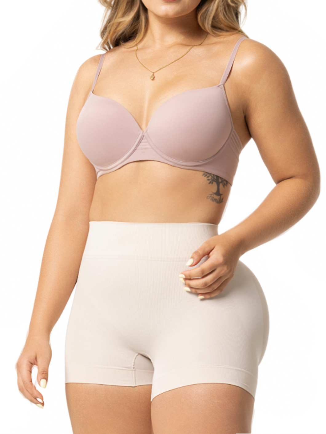 Woman wearing a light pink bra and beige shapewear on a white background
