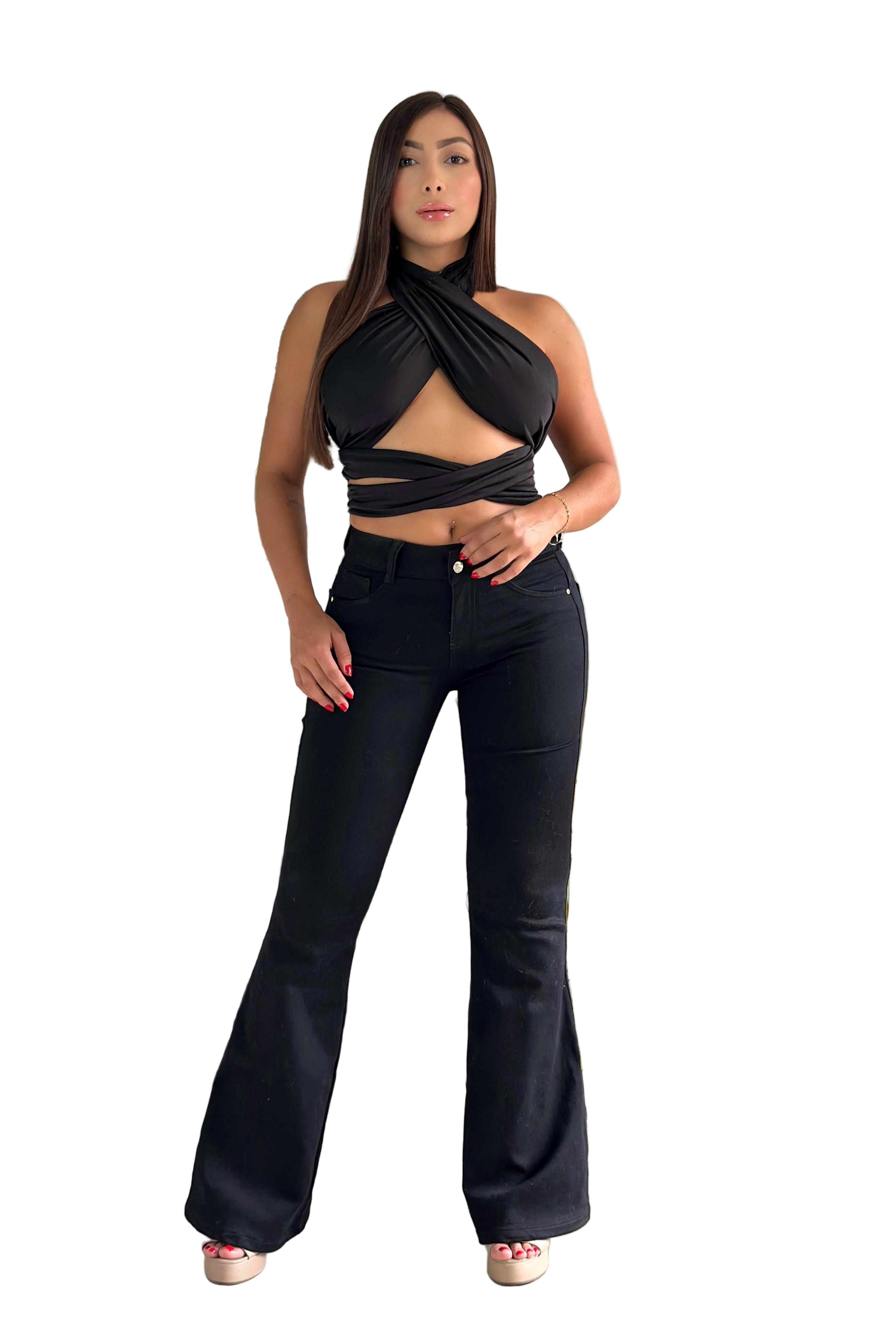 Woman wearing a black top and black jeans standing in a living room.