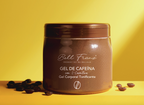 A brown cosmetic jar of Bell Franz 'Gel de Caffeína con L-Carnitine' (Caffeine Gel with L-Carnitine) set against a bright yellow background with scattered coffee beans on the surface.