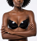 Woman wearing a black bra against a white background