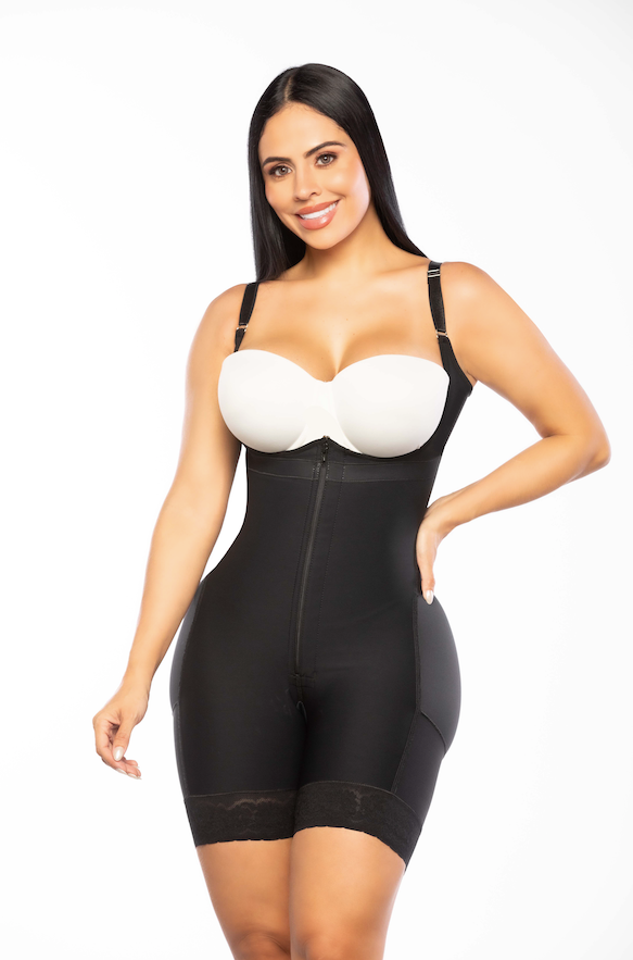 Woman wearing a black shapewear garment with a white top on a white background