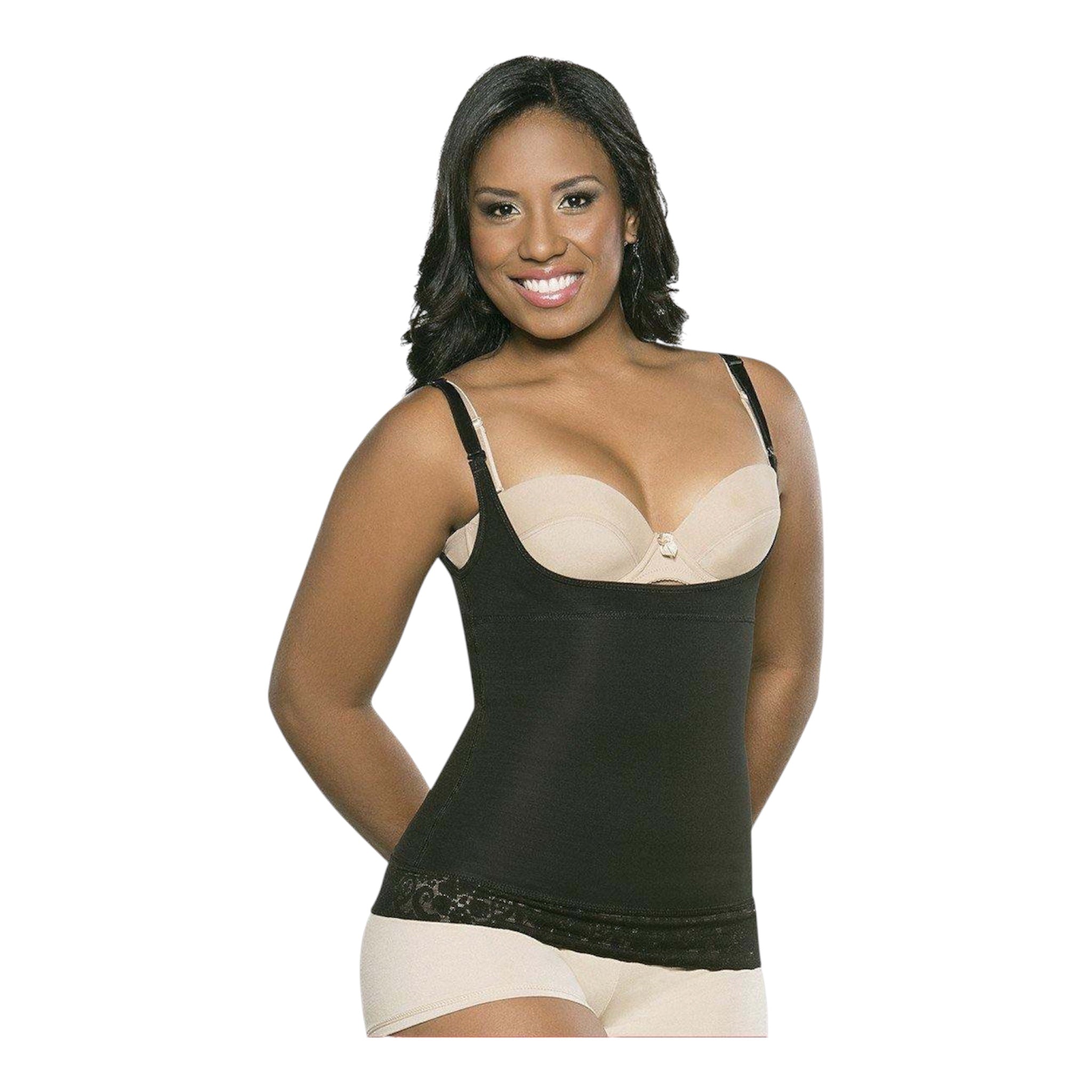 A woman with dark hair smiling while modeling a black open-bust compression tank top shapewear garment. The shapewear fits tightly around her torso, featuring thin adjustable straps and a lace border at the bottom hem. She is wearing it over a beige bra and matching boy-short underwear, set against a plain light gray background