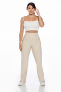 Woman wearing a white top and beige pants on a white background