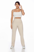 Woman wearing a white top and beige pants on a white background