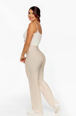 Woman wearing a white top and beige high-waisted pants on a white background