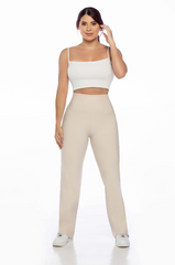 Woman wearing a white top and beige pants on a white background