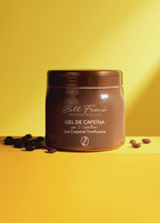 A brown jar of Bell Fránci coffee gel body tonic on a bright yellow background with scattered coffee beans.