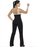 Woman wearing a black jumpsuit lifting a purple dumbbell on a white background