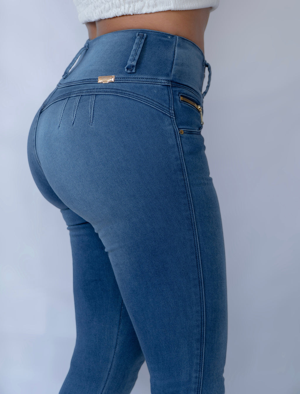 Stella's Corset blue denim skinny butt-lifter jeans with front zipper accents and no back pockets.