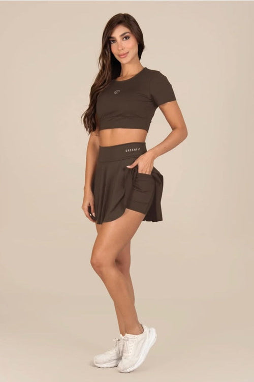 Stella's Corset olive green athletic skirt with side pocket worn by a model with a matching crop top and sneakers